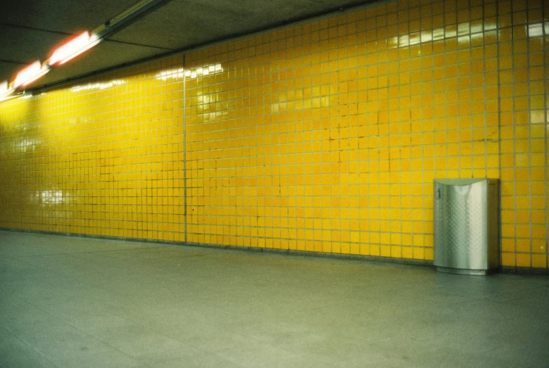 a yellow wall and a black box at the end