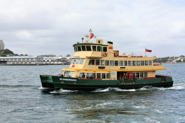 the large boat is driving in the water near a dock