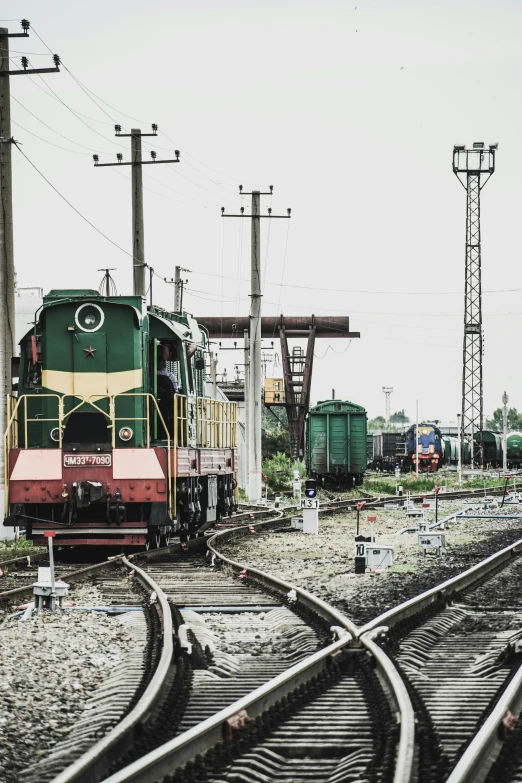 two railroad tracks and a freight train sitting on the train station