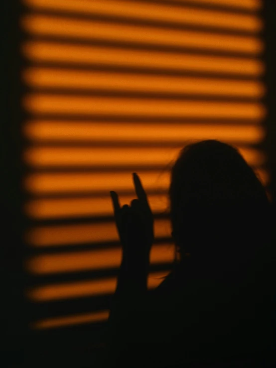 silhouette of person touching a cell phone by shadowing it