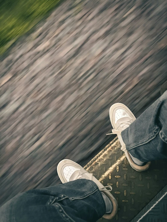 a person in white tennis shoes stands on a skateboard