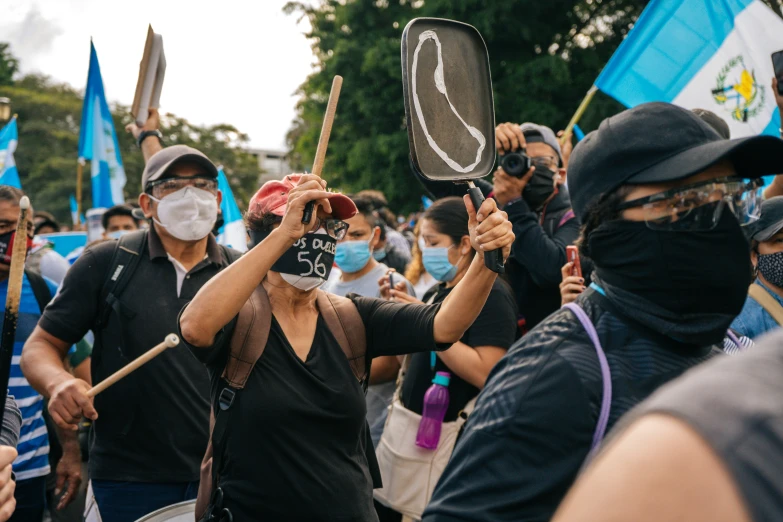 woman wearing a mask and holding up signs