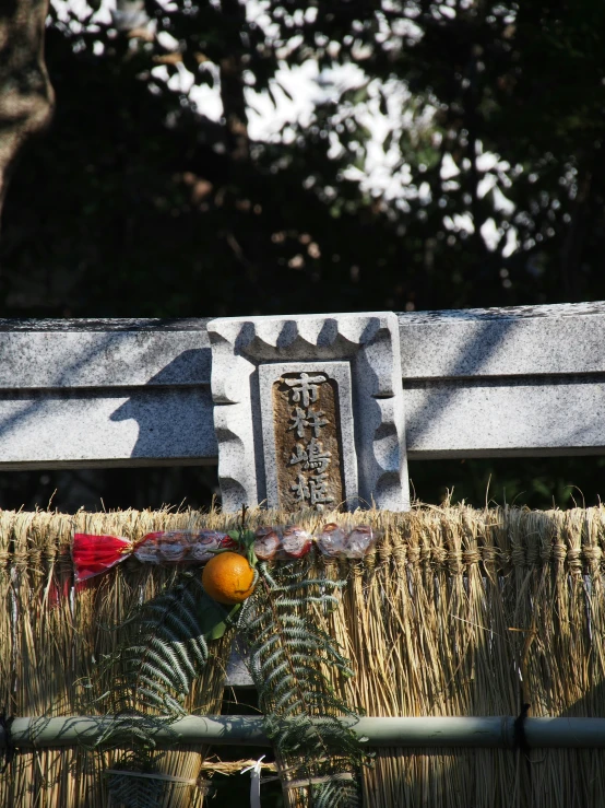 a grave with decorative decorations and a straw hat is viewed through the railing