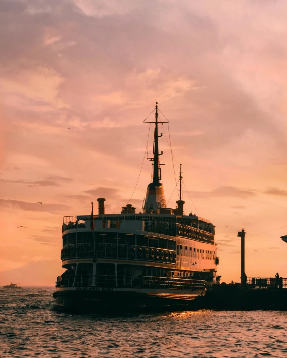 a boat sailing in the ocean with a large ship next to it