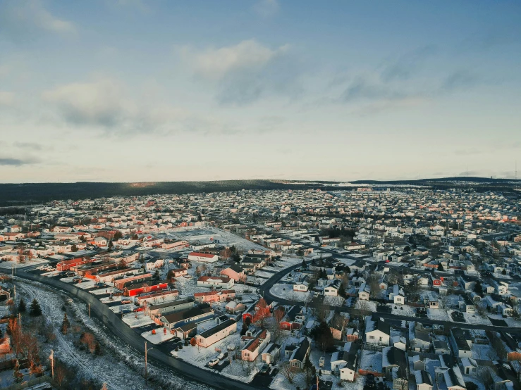 snow covers the roofs and houses along a road