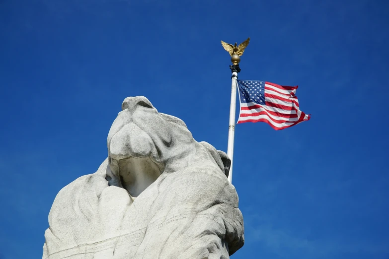 the american flag and a statue atop a church