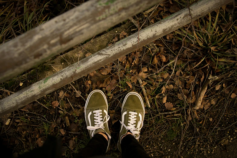 a person wearing green tennis shoes standing on the grass