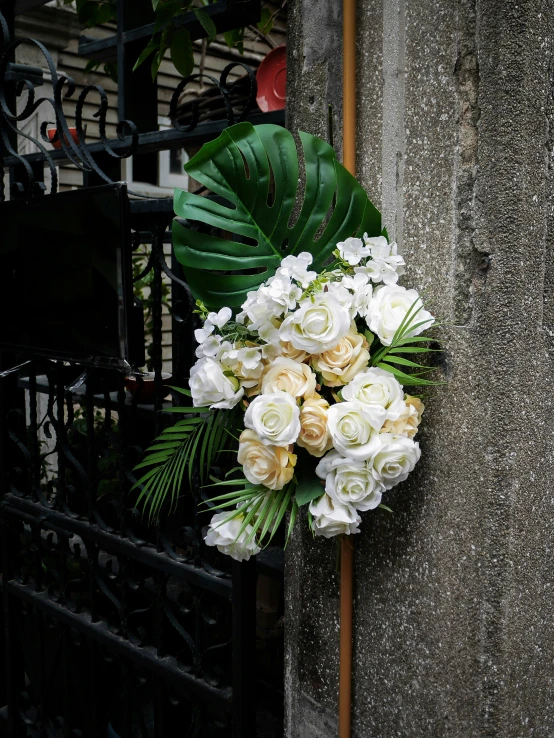 the bouquet of flowers is sitting on the fence