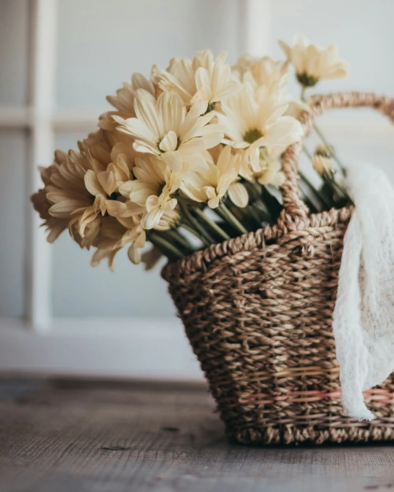 a basket of flowers is wrapped in white cloth