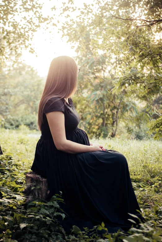 a woman sitting on top of a tree stump