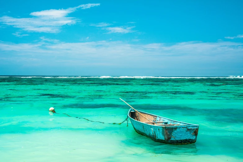 an old boat is anchored to the side of the beach