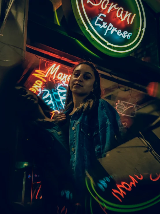 woman standing in front of neon lights holding a case