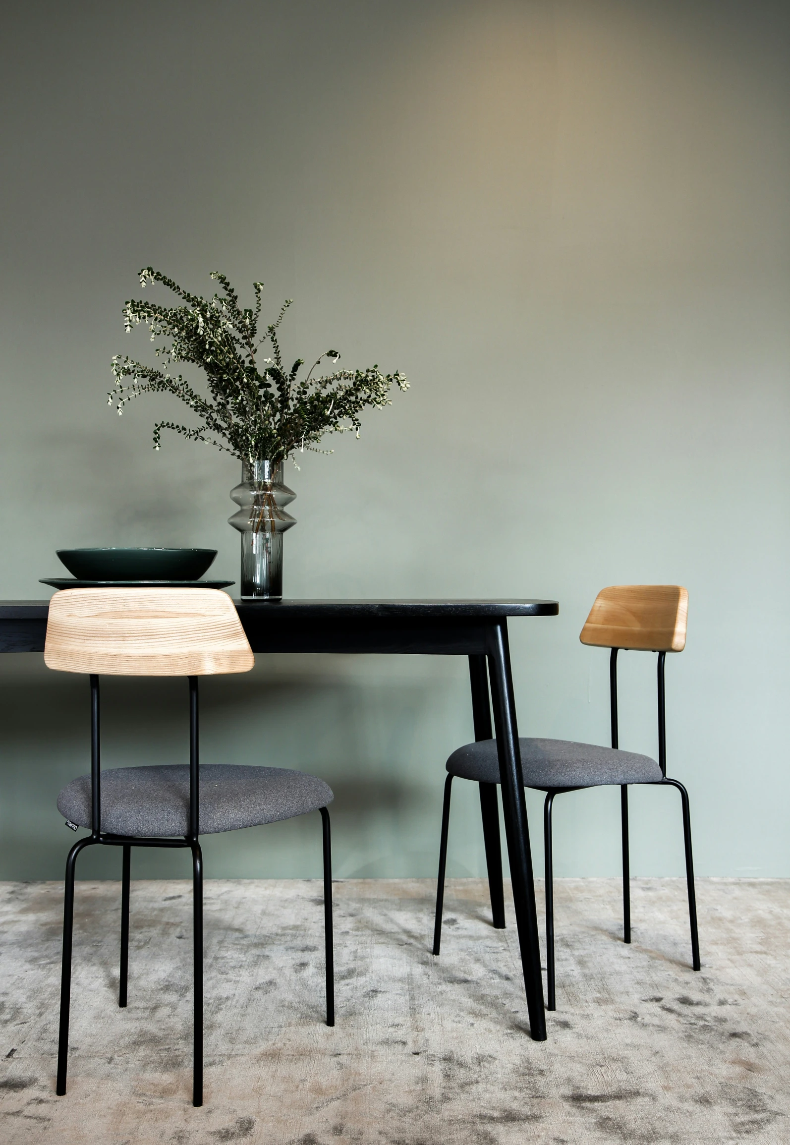 a kitchen table with a plant and two chairs next to it