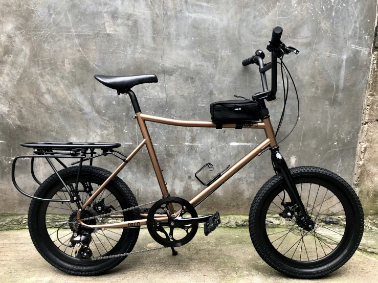 a brown bicycle parked against a wall