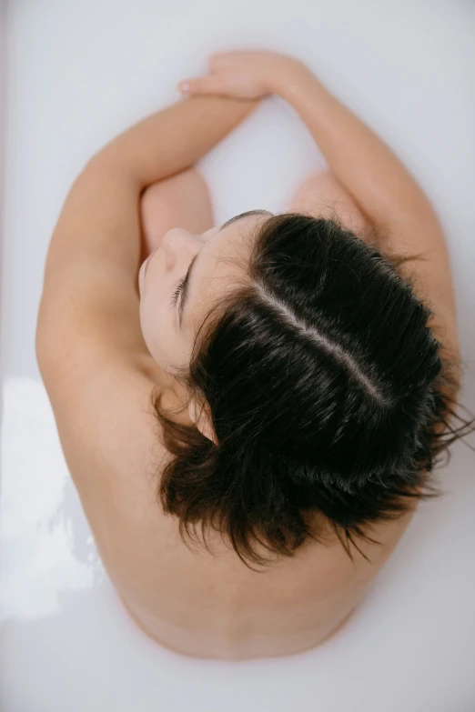 the woman is lying down in a bathtub