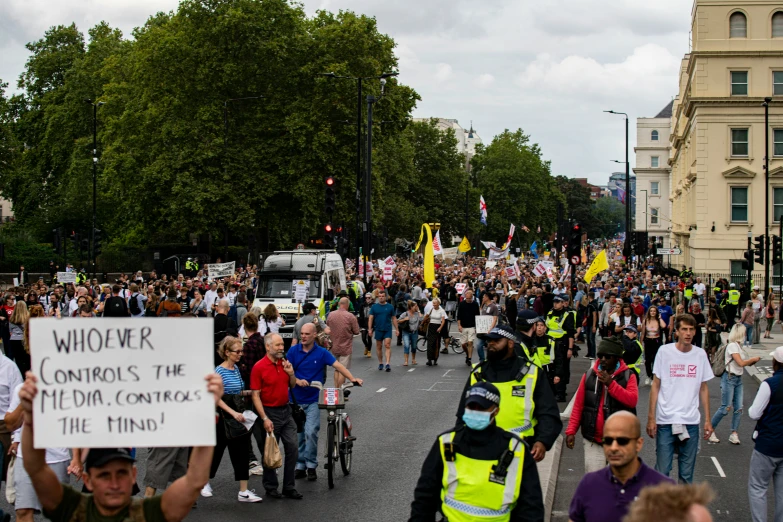 a crowd is walking in the street with protest signs