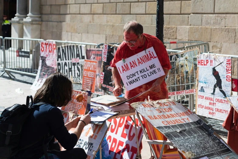 a man with a protest sign standing in front of many signs