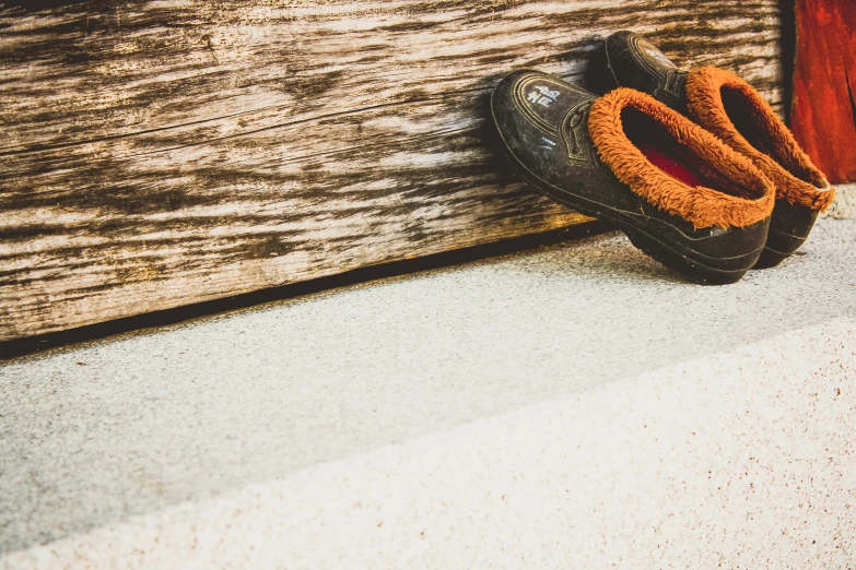 a brown pair of shoes resting on a wooden panel