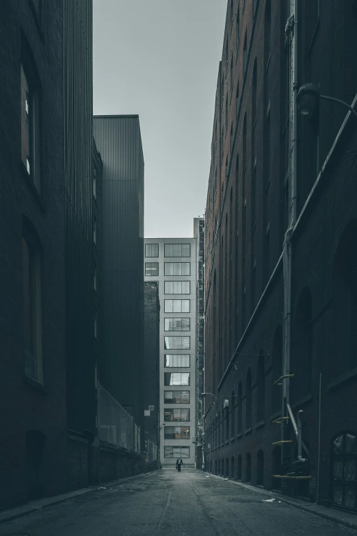 a person standing alone in a street surrounded by buildings