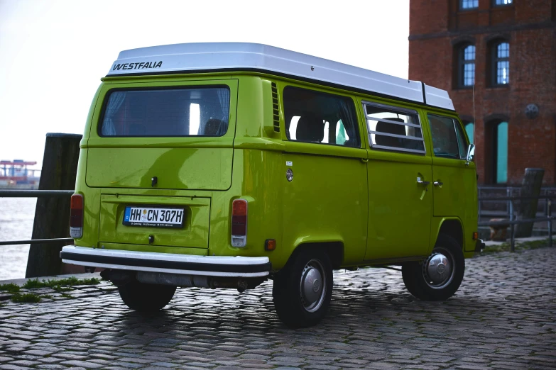 an old van sits in front of a brick building