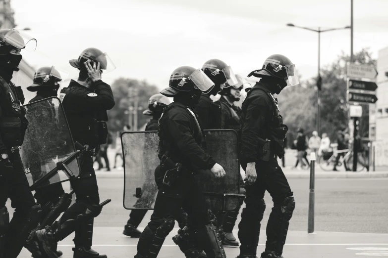 some men in police gear standing in the street