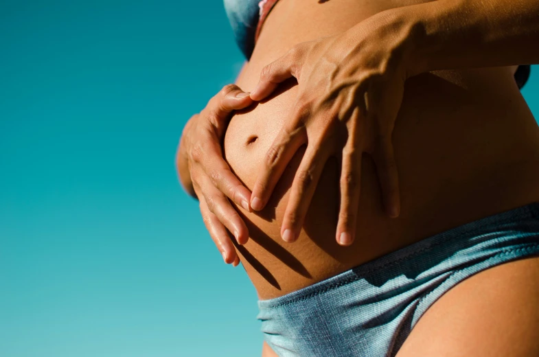 a women is holding her stomach with both hands