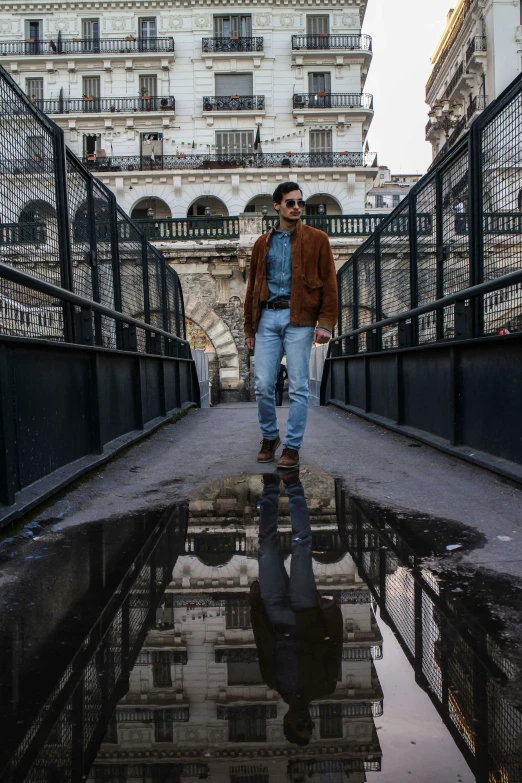 a man is walking across an iron bridge