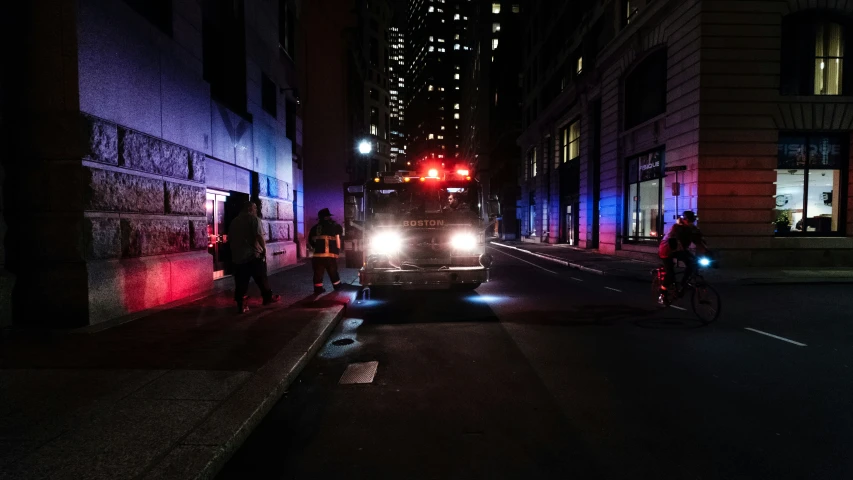 a city street at night with people walking, and street light in view