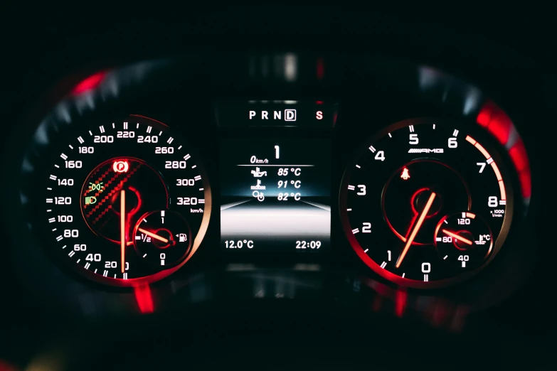 an electronic gauge with red words on a black surface