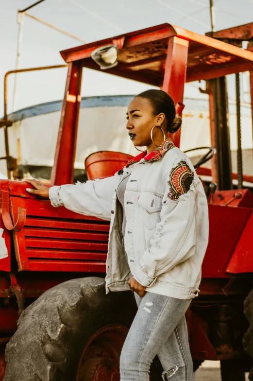 a woman leaning on the wheel of a tractor