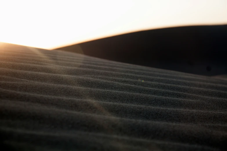 a light that is shining in the sky above some sand