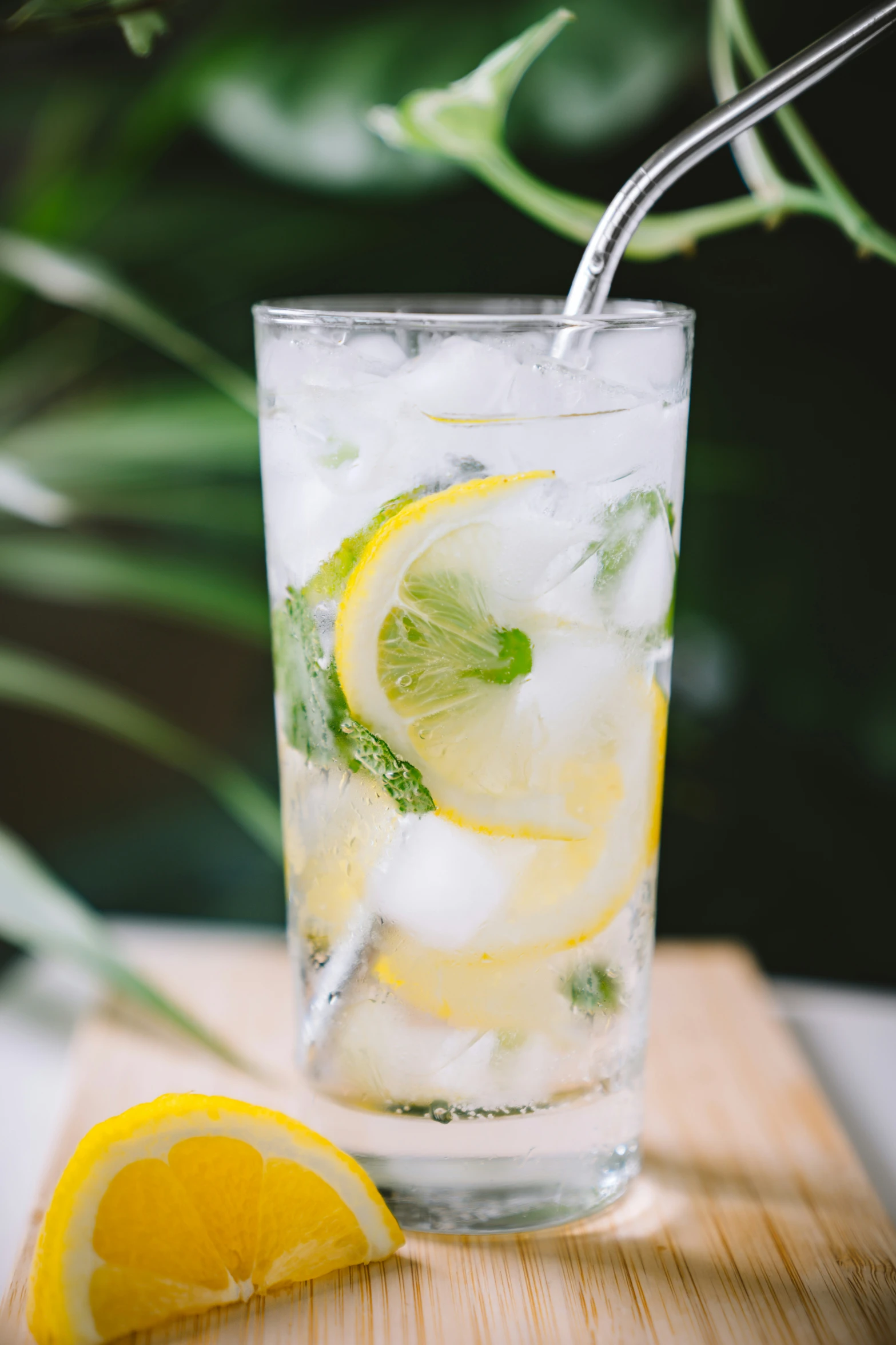 a glass with ice and lemons with a straw on top