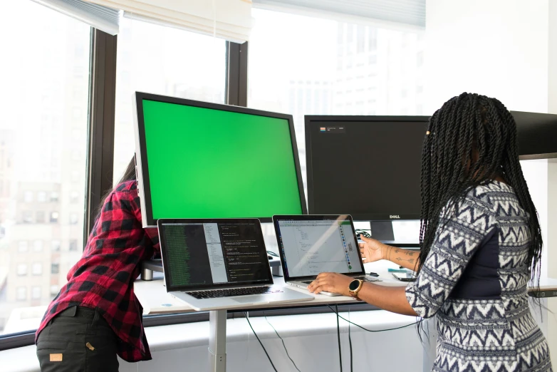 two people working on laptops that are turned on