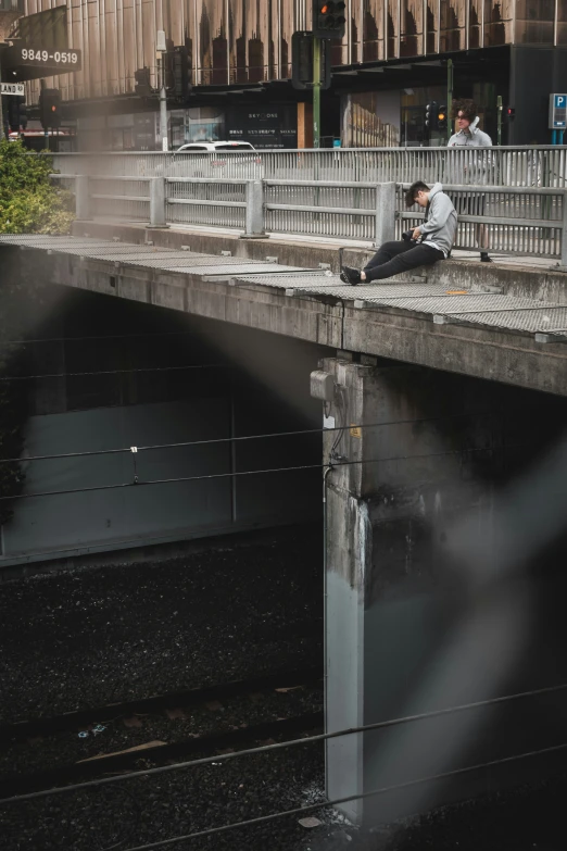 two people on a bridge next to each other