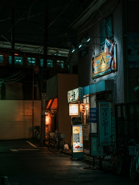 an outside cafe at night with neon signs and bikes