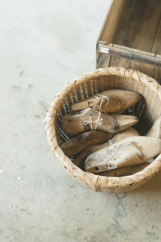 an old wooden basket containing wooden shoes and a suitcase