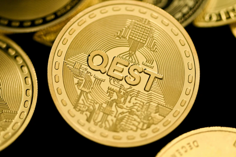 a close up of two coins and the coin says qes