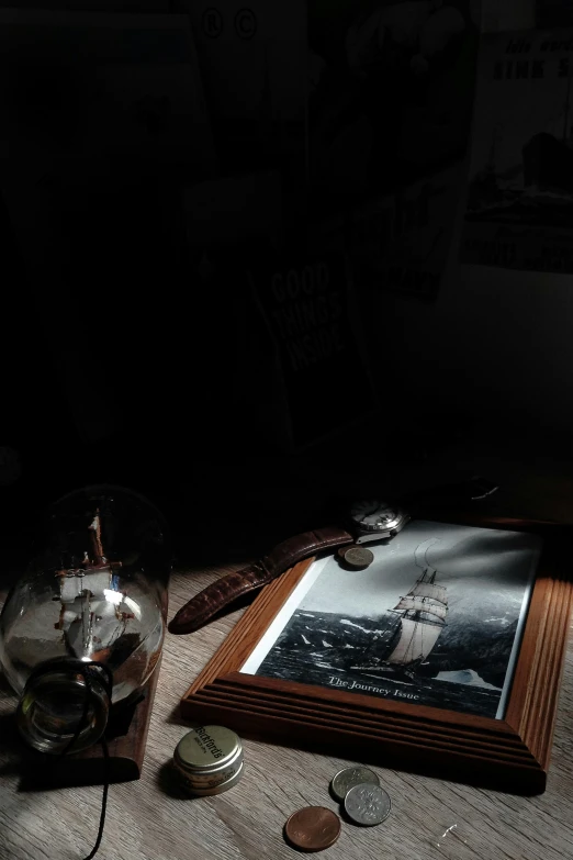 a wooden object sits on a wooden table next to a framed picture