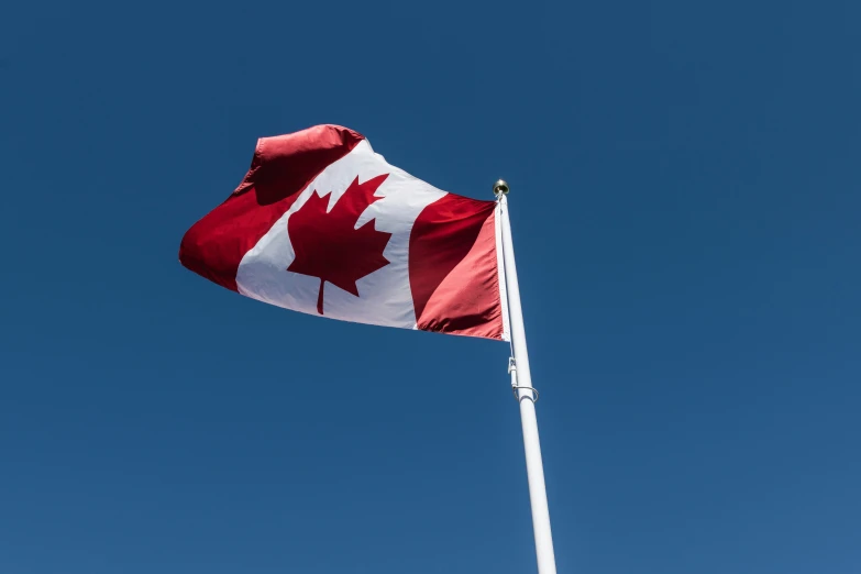 a canadian flag flying high in the air