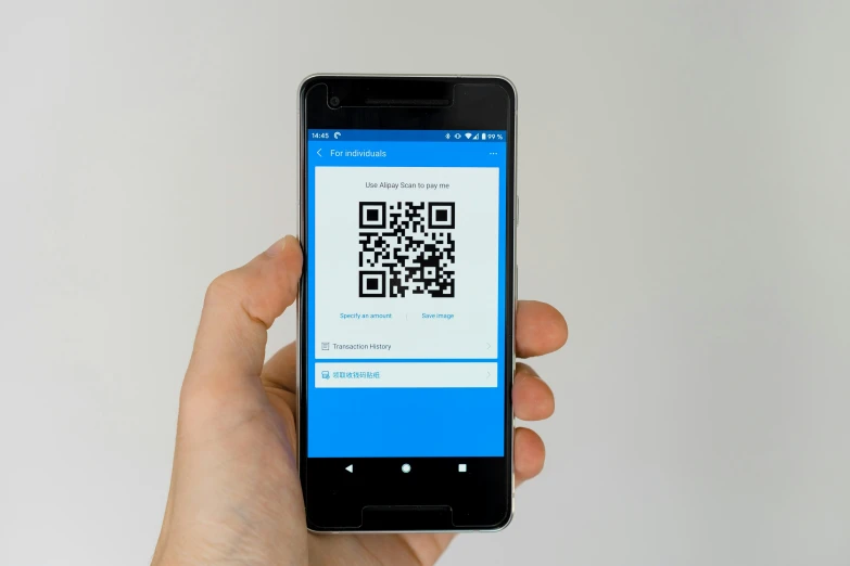 a hand holding a smart phone with a qr code displayed on the screen