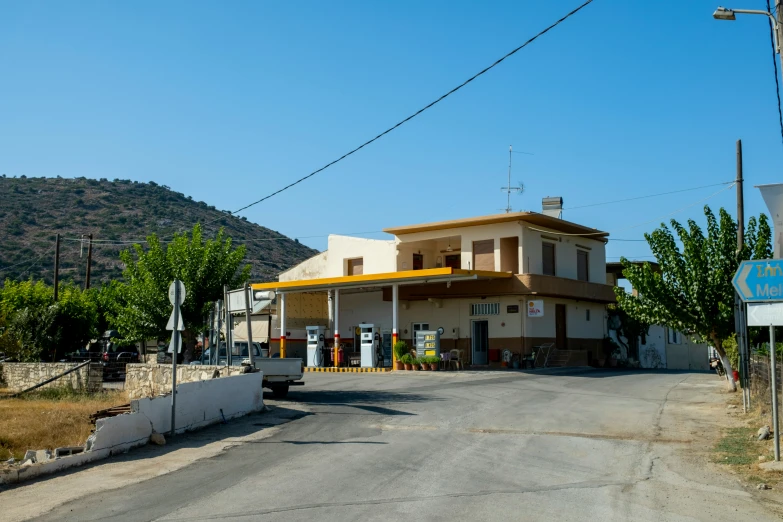 a yellow building on a corner with mountains in the background