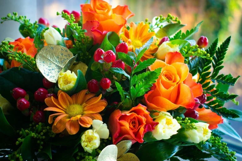 a bouquet of different colored flowers sitting in front of a window