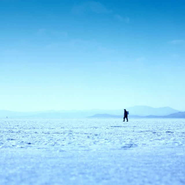 a lone man standing alone on an almost empty plain