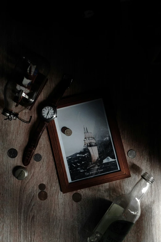 an old fashioned pirate ship on a table next to several small jars of coins