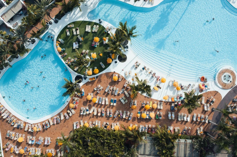 a beach resort with a large pool and lounge chairs