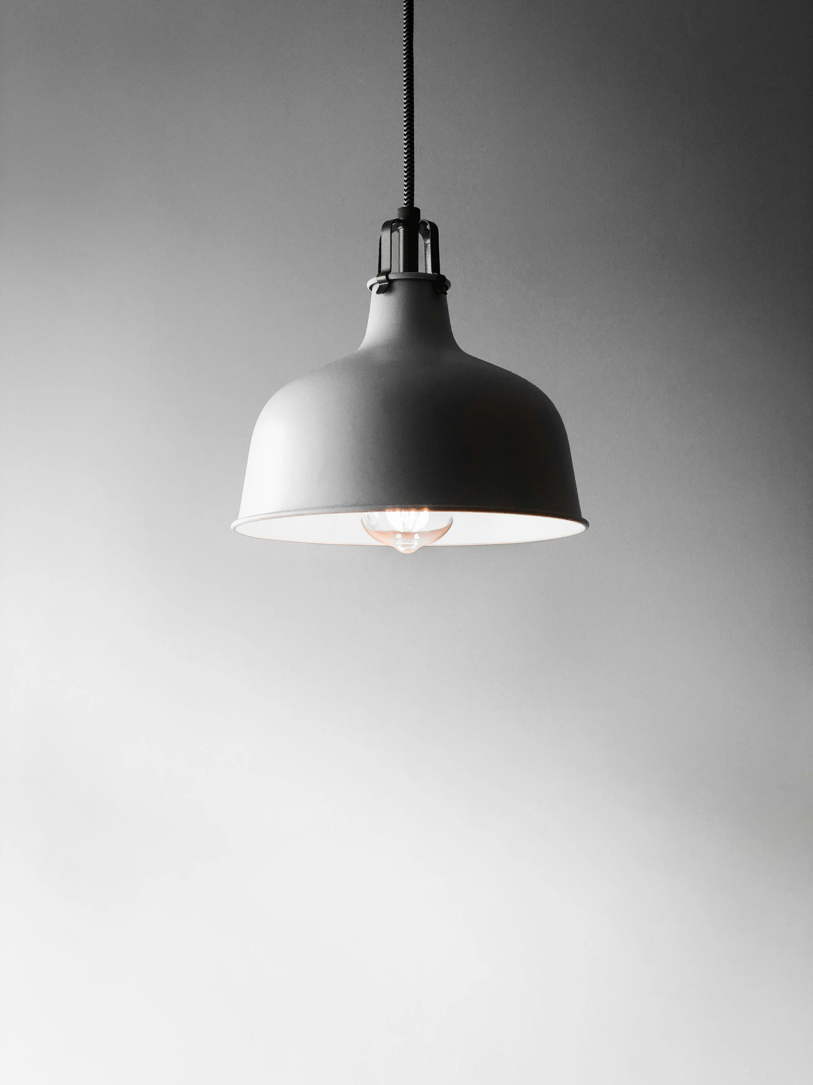 a large gray hanging light hanging from a gray ceiling