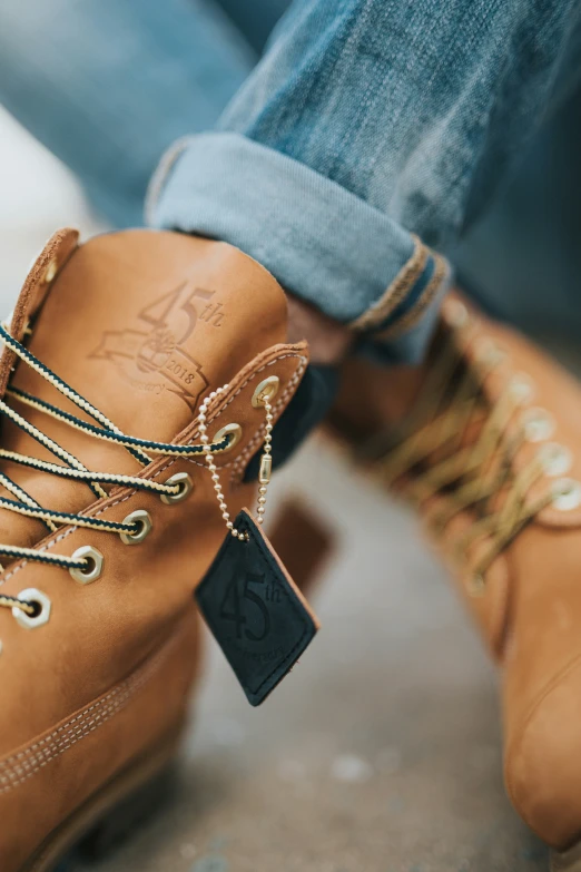 a man sitting down wearing boots with gold chains on them