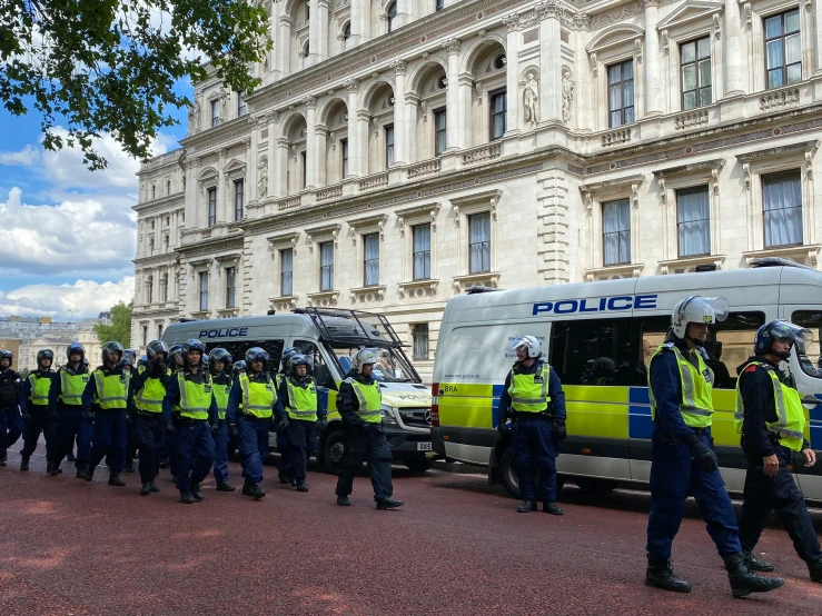 a large group of police standing next to each other in front of a building