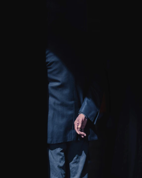 a man in a blue suit holding on to his hand