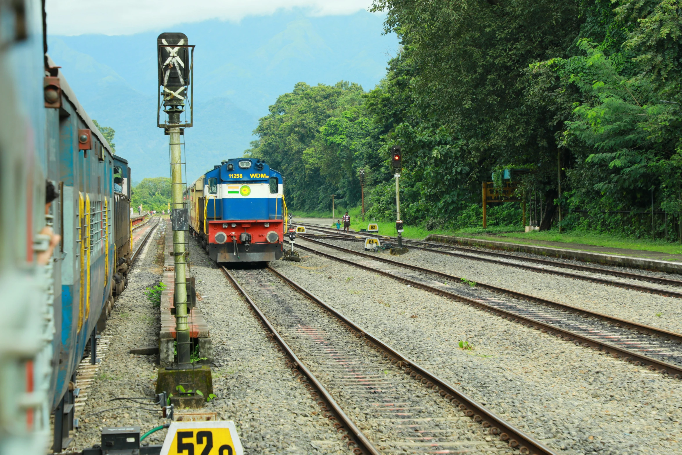 train on train tracks with multiple signs at railyard